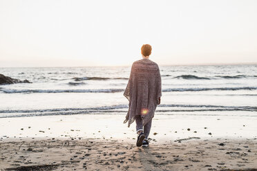 Frankreich, Halbinsel Crozon, Frau geht bei Sonnenuntergang am Strand spazieren - UUF008345