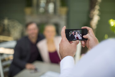Mann macht Smartphone-Foto von Paar in Außenrestaurant - ZEF010256
