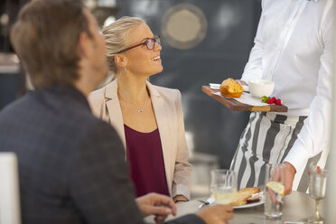 Kellner serviert Essen an einem Tisch für zwei Personen - ZEF010266