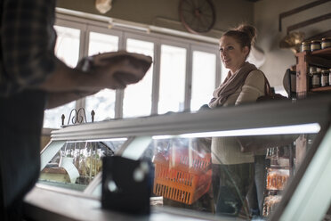 Woman talking to butcher in butchery - ZEF010284