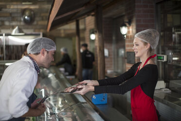 People working in butchery looking at meat - ZEF010306