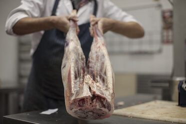 Butcher holding carcass in butchery - ZEF010323