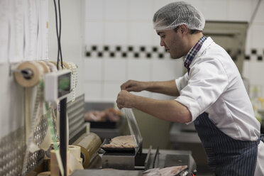 Metzger verpackt frisches Fleisch in der Metzgerei - ZEF010326