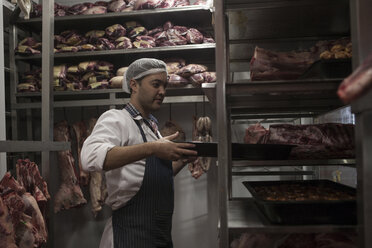 Butcher carrying tray in butchery cold store - ZEF010339