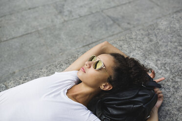 Relaxed young woman lying down enjoying the sunshine - MRAF000165