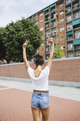 Back view of young woman listening to music outdoors - MRAF000175