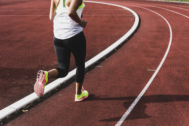 Austria, Teenage girl running on track, portrait stock photo