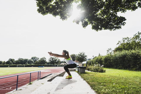 Young woman practicing in a track and field stadium stock photo