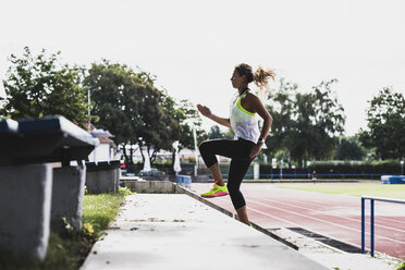 Junge Frau beim Training in einem Leichtathletikstadion - UUF008372