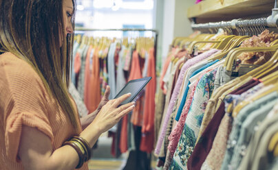 Woman using tablet in a boutique - DAPF000323