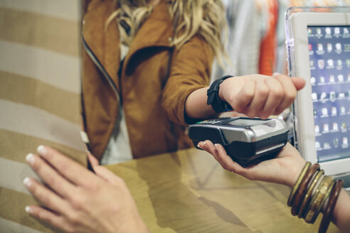 Woman paying using smartwatch with NFC technology in a store - DAPF000328