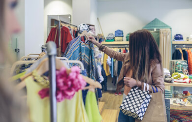 Frau kauft Kleidung in einer Boutique - DAPF000344