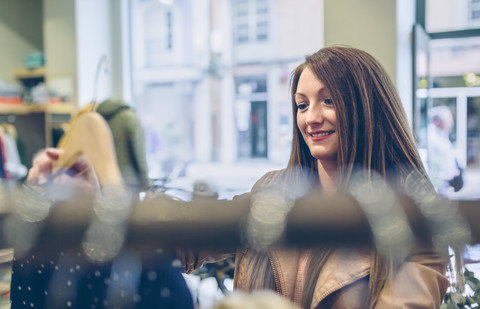 Lächelnde Frau beim Einkaufen von Kleidung in einer Boutique, lizenzfreies Stockfoto