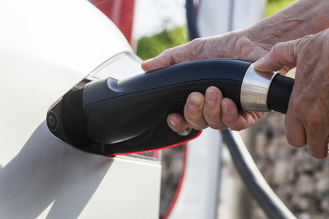 Aufladen eines Elektroautos, Nahaufnahme, lizenzfreies Stockfoto