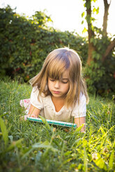 Little girl lying on a meadow using tablet - LVF005285