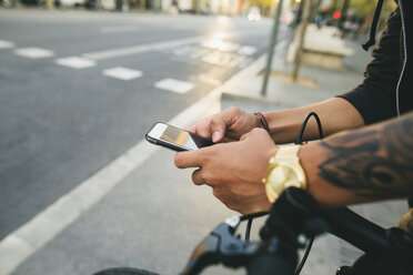 Teenager with a fixie bike, using smartphone - EBSF001726