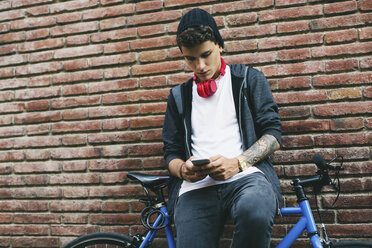 Teenager with a fixie bike, using smartphone - EBSF001751