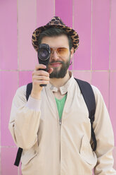 Young man using a vintage video camera filming viewer - RTBF00345