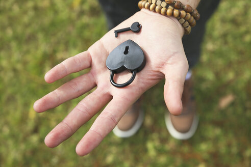 Heart-shaped love lock and key on man's palm, close-up - RTBF00347