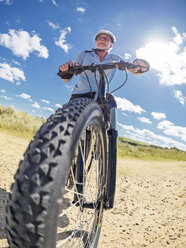 Frankreich, Bretagne, älterer Mann auf elektrischem Mountainbike auf Küstenpfad - LAF01718