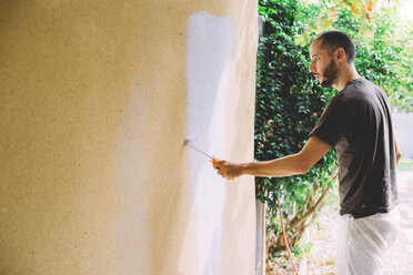 Man painting wall with paint roller - GEMF01009