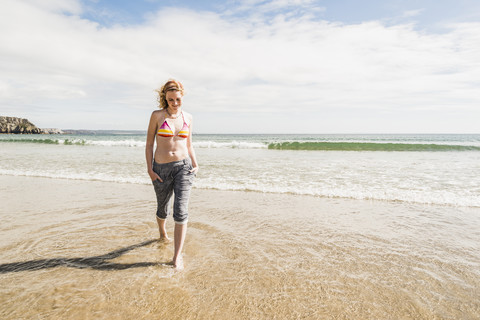 Jugendliches Mädchen watet im Meer, lizenzfreies Stockfoto