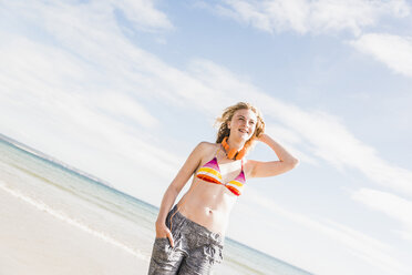 Teenage girl standing on the beach - UUF08403