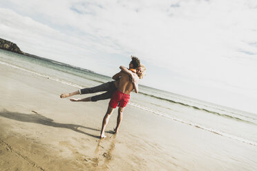 Playful teenage couple on the beach - UUF08412