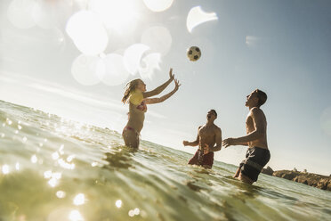 Freunde spielen mit einem Ball im Meer - UUF08428