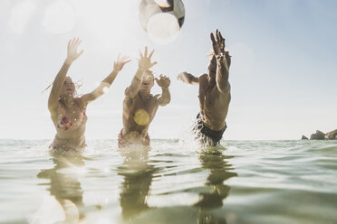 Freunde spielen mit einem Ball im Meer - UUF08430