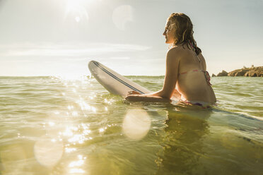 Teenage girl with surfboard in the sea - UUF08436