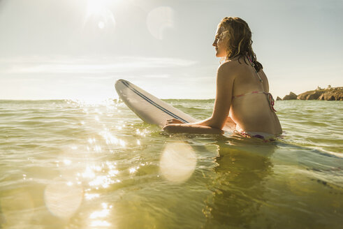 Teenager-Mädchen mit Surfbrett im Meer - UUF08436
