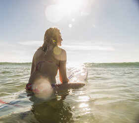 Teenage girl with surfboard in the sea - UUF08437