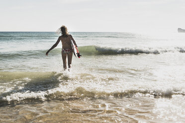 Teenager geht mit Surfbrett ins Meer - UUF08446