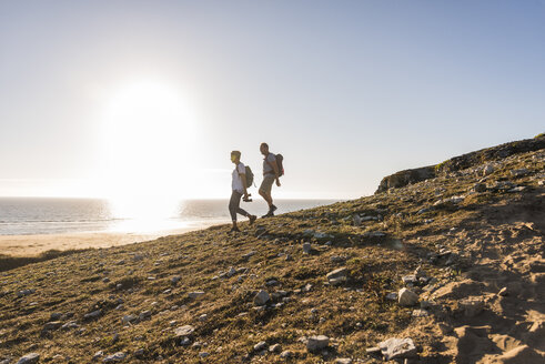 France, Bretagne, Finistere, Crozon peninsula, couple during beach hiking - UUF08459