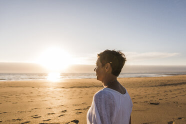 Frankreich, Bretagne, Finistere, Halbinsel Crozon, Frau bei Sonnenuntergang am Strand - UUF08480