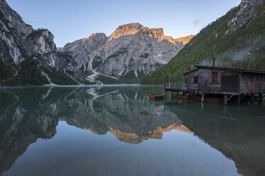 Italien, Südtirol, Dolomiten, der Berg Croda del Becco und der kleine hölzerne Kirchturm spiegeln sich im Pragser Wildsee bei Sonnenaufgang - LOMF00385