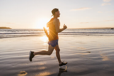 France, Crozon peninsula, jogger on the beach at sunset - UUF08486