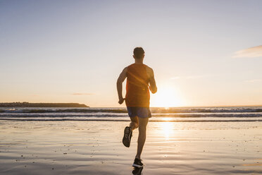 France, Crozon peninsula, jogger on the beach at sunset - UUF08490