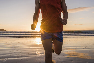 Frankreich, Halbinsel Crozon, Jogger am Strand bei Sonnenuntergang - UUF08491