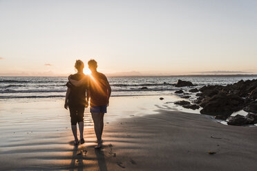 Frankreich, Halbinsel Corzon, Paar geht bei Sonnenuntergang am Strand spazieren - UUF08500