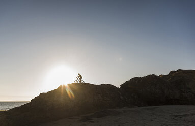 France, Crozon peninsula, mountainbiker at sunset - UUF08508