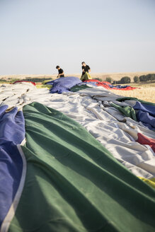 Zwei Männer packen eine Heißluftballonhülle ein - ABZF01237