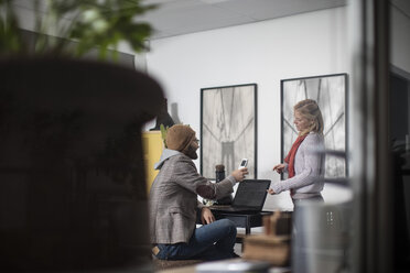 Junger Mann und Frau arbeiten zusammen in einem Designer-Büro - ZEF10359