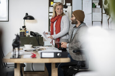 Junger Mann und Frau arbeiten zusammen in einem Designer-Büro - ZEF10364