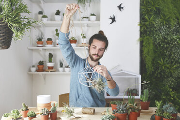 Plant collector preparing the pendant for an air plant - RTBF00359