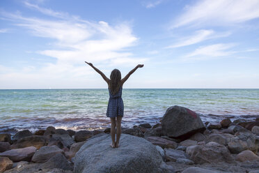 Back view of girl with raised arms looking to the sea - SARF02870