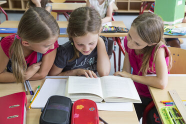 Drei Schulmädchen lesen ein Buch - SARF02890