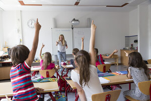 Aktive Schüler, die ihre Hände in der Klasse heben - SARF02896