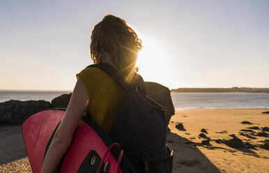 Teenager-Mädchen am Strand mit Surfbrett - UUF08514